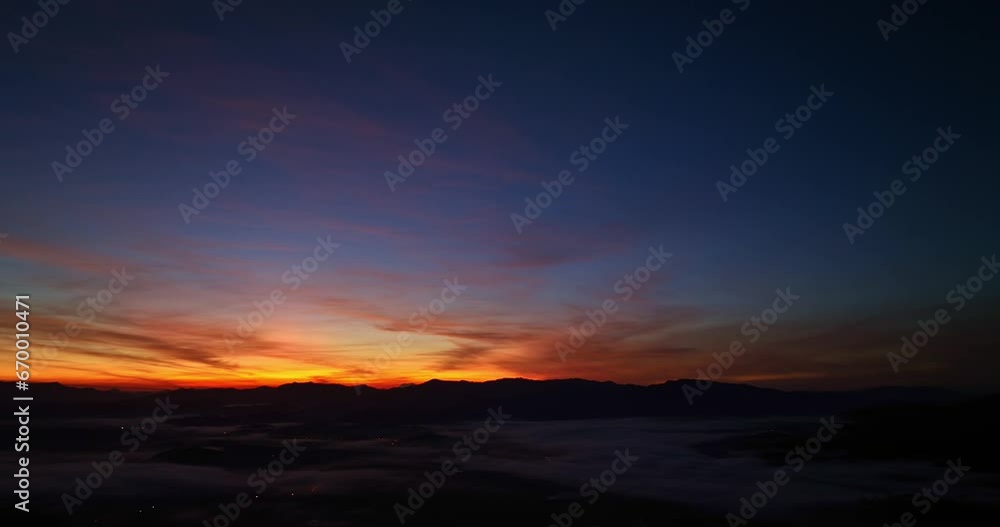 .aerial view scenery sunrise above the mountain in tropical rainforest..slow floating fog blowing cover on the mountain look like as a sea of mist. .beautiful sunrise in the mist background. .aerial view scenery sunrise above the mountain in tropical rainforest..slow floating fog blowing cover on the mountain look like as a sea of mist. .beautiful sunrise in the mist background.
