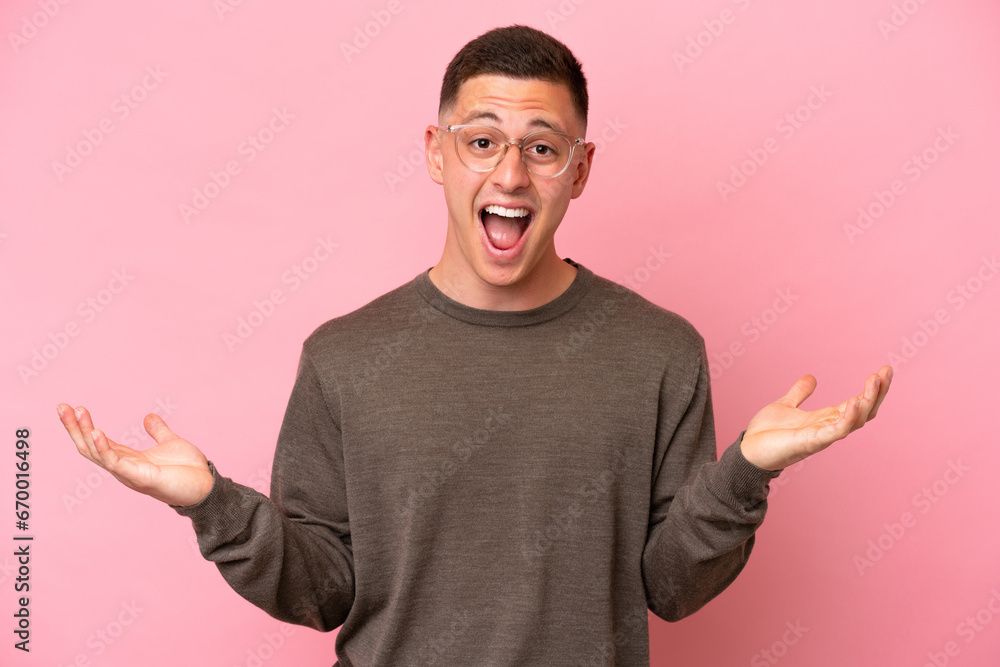 Young Brazilian man isolated on pink background with shocked facial expression Young Brazilian man isolated on pink background with shocked facial expression