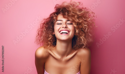Radiant woman with curly hair laughs heartily.