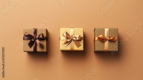 top view of three gift boxes with satin ribbons on a beige background