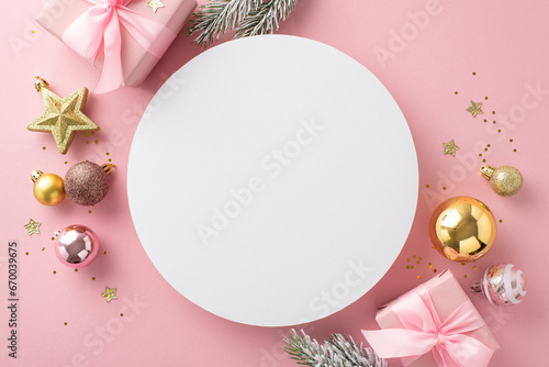 Sparkling Holiday Celebration idea. Top view of beautiful gifts, adorable tree ornaments, glistening stars, twinkling sequins, frost-kissed evergreen branches on pastel pink with circle for greetings photo