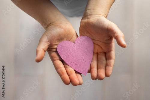 love and kindness, child hands holding paper heart, affection, bonding and care concept