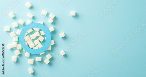 Raise Diabetes Awareness: Top view of a blue circle emblem on a pastel blue background with refined sugar. Perfect for promoting Diabetes Awareness Month