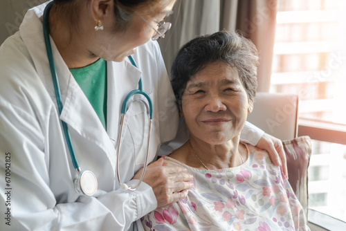 Elderly senior dementia patient (aging old adult person) in nursing hospice home with geriatrician doctor having happy medical health care from hospital carer, caretake or caregiver healthcare service photo
