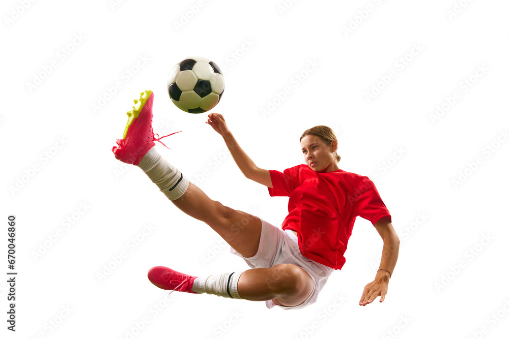 Concentrated game. Young girl, football player hitting ball in motion and falling down isolated on white background. Concept of sport, competition, action, success, motivation. Copy space for ad