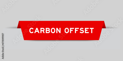 Red color inserted label with word carbon offset on gray background