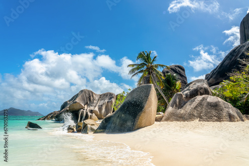 Granite rocks and palm trees on the scenic tropical sandy Anse Source d'Argent beach, La Digue island, Seychelles