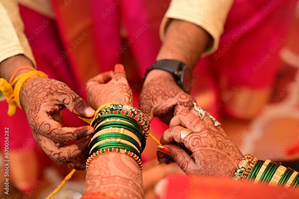 Indian bride Tie a Turmeric Thread on hand of groom. Close Up Hands of bride and Groom in hindu wedding. Marathi Wedding Ceremony. Maharashtra Culture. Hindu wedding rituals and ceremony. Yellow knot