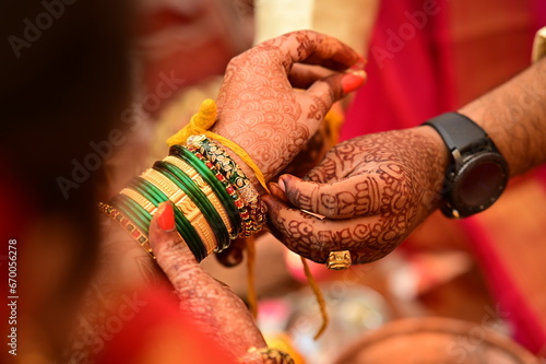 Indian bride Tie a Turmeric Thread on hand of groom.  Yellow knot. Hands of bride and Groom in hindu wedding. Marathi Wedding Ceremony. Maharashtra Culture. Hindu wedding rituals and ceremony. 