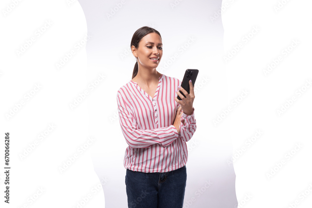 young brunette business woman dressed in a striped shirt chatting on a smartphone young brunette business woman dressed in a striped shirt chatting on a smartphone
