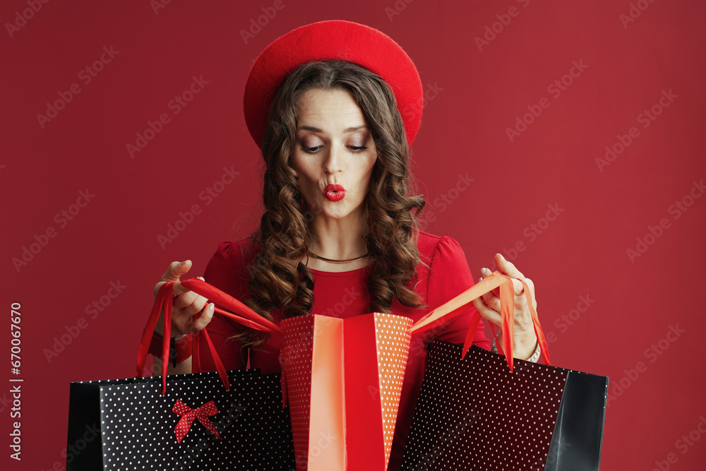 Φωτογραφία surprised stylish woman in dress and beret with shopping bags
