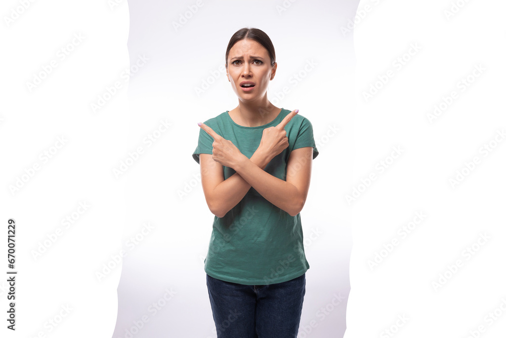 young beautiful brunette lady dressed in a green t-shirt and jeans crossed her arms in disagreement young beautiful brunette lady dressed in a green t-shirt and jeans crossed her arms in disagreement
