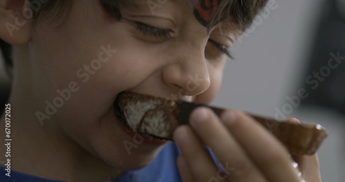 One small boy taking a bite of toast bread  close-up child mouth eating carb food in speed ramp