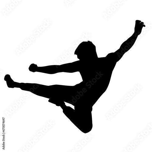 Silhouette of a muscular man of martial art fighter doing flying kick pose.