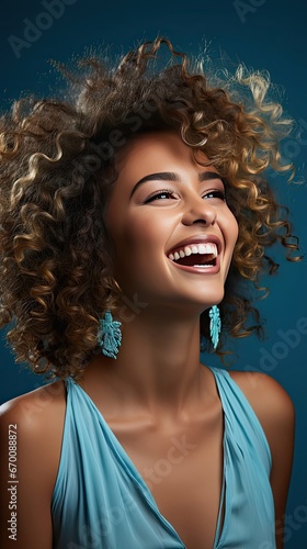 Portrait of happy young black woman laughing against blue wall. Smile emotion illustration. Generative AI © tanyastock