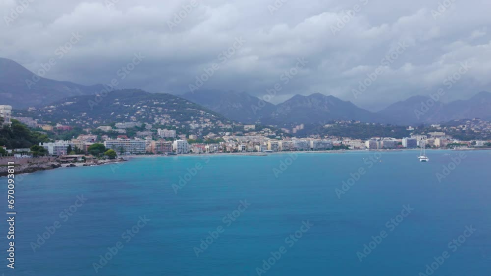 Aerial view of The French Riviera at Menton, France. Footage was shoot from a drone at a higher altitude from above the bay with the city and the mountains in the background on a stormy weather. Aerial view of The French Riviera at Menton, France. Footage was shoot from a drone at a higher altitude from above the bay with the city and the mountains in the background on a stormy weather.