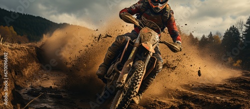 Professional enduro cyclists in full gear perform on a sandy arena