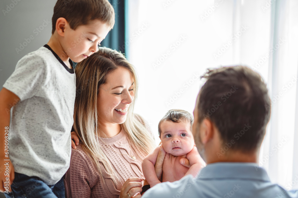 family on bedroom with his newborn baby son family on bedroom with his newborn baby son