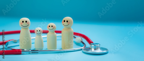 Tableau sur toile Health insurance concept, wooden dolls, family of parents and children, happy smiling faces, surrounded by stethoscopes, bright blue background