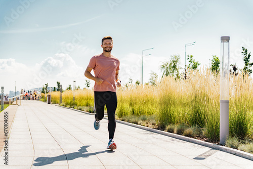 Healthy and active lifestyle. Strong man daily fitness exercises. A running athletic man smiles at a happy workout man in sportswear.