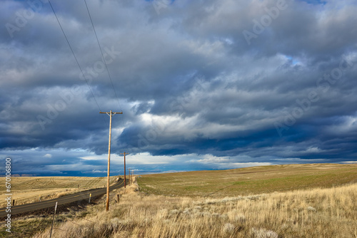 Road among fields under a dramatic sky in Eastern Oregon.