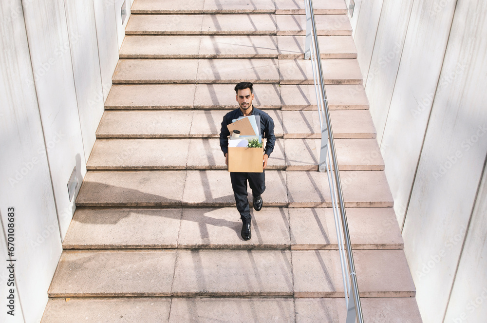 middle eastern businessman carrying cardboard box walking up staircase outdoor middle eastern businessman carrying cardboard box walking up staircase outdoor