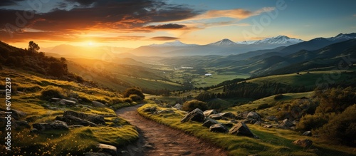 Landscape of mountain climbing trails and beautiful valley views, with sunset in the background.
