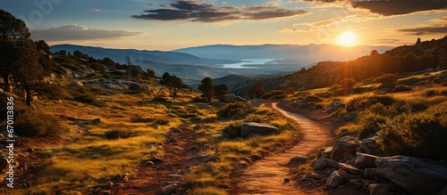 Landscape of mountain climbing trails and beautiful valley views, with sunset in the background.