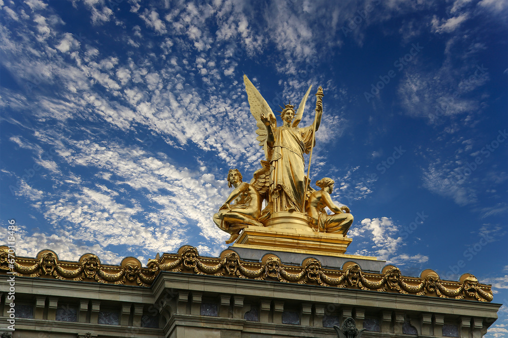 Golden statue of Liberty on the roof of the Opera Garnier (Garnier Palace)  against the sky with clouds. Sculpted by Charles Gumery in 1869. Paris, France. UNESCO World Heritage Site