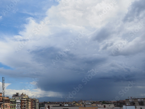 The storm or hurricane is coming. Beautiful dark summer rainy clouds in a blue sky background covered the Rome city in Italy © LifeCollectionPhoto