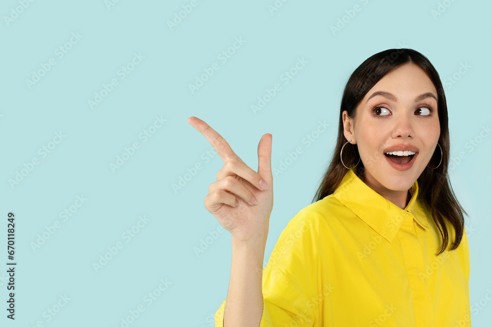 Excited pretty woman pointing at copy space and grimacing Excited pretty woman pointing at copy space and grimacing
