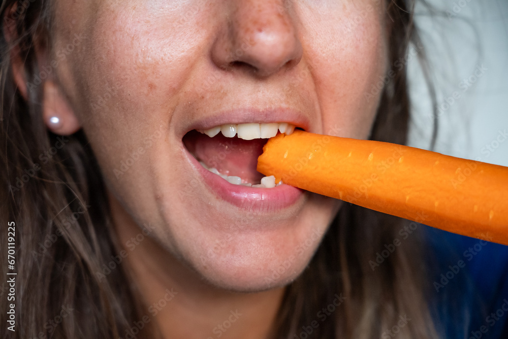 Woman eats food. Woman eats carrot. Close shot of girl eating carrot. Face while eating carrots.