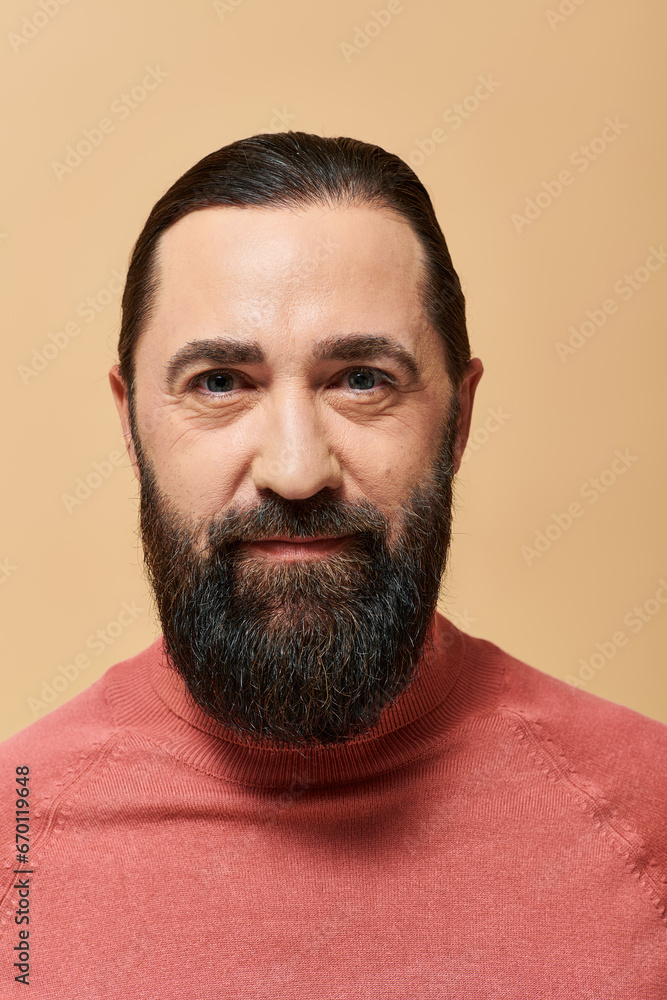 portrait of handsome man with beard posing in pink turtleneck jumper on beige background portrait of handsome man with beard posing in pink turtleneck jumper on beige background