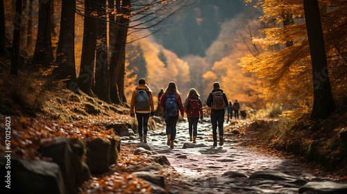 Uma imagem pitoresca de uma família ou grupo de amigos fazendo trilha por uma floresta com folhagem vibrante de outono no Dia de Ação de Graças. photo
