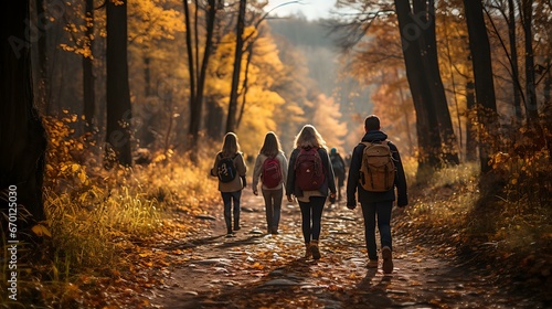 Uma imagem pitoresca de uma família ou grupo de amigos fazendo trilha por uma floresta com folhagem vibrante de outono no Dia de Ação de Graças. © Alexandre