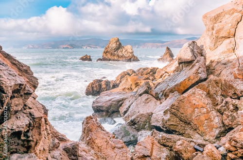 Beautiful landscape  raw power and beauty of the ocean  close-up. The rough texture of the rocks contrasts with the fluidity of the water and waves  evoking a sense of awe and wonder.