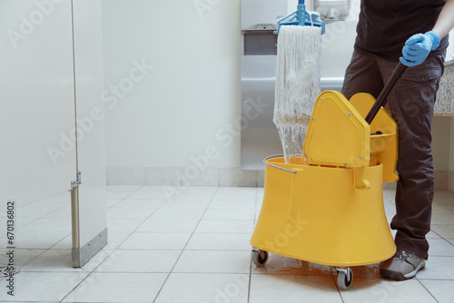 unrecognizable woman using a yellow mop bucket photo