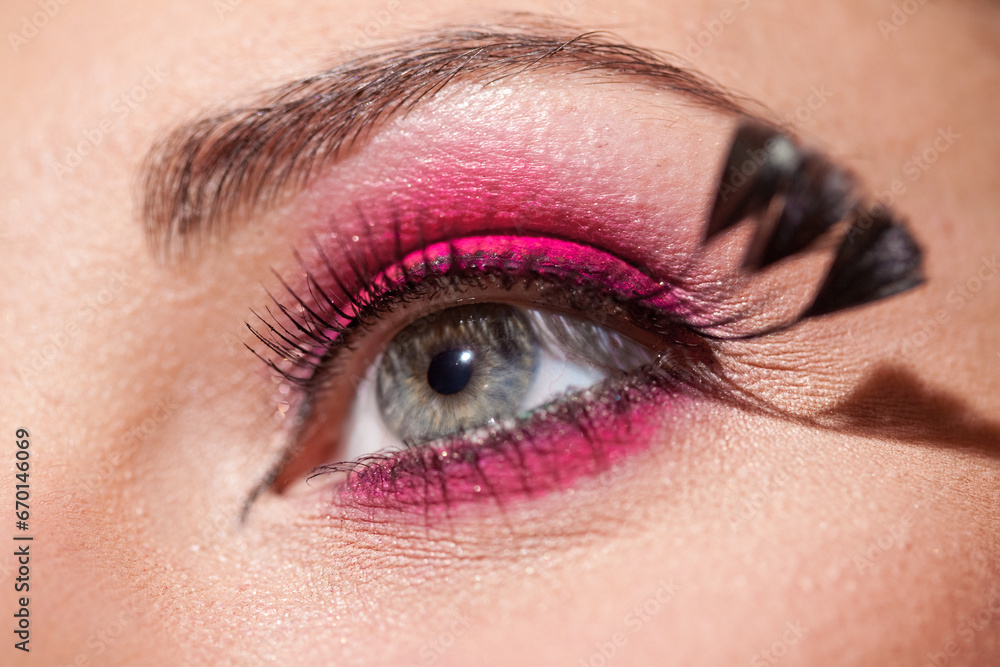 Obraz premium Crop of female eye with colorful make up. Beautiful fashion model with creative art makeup