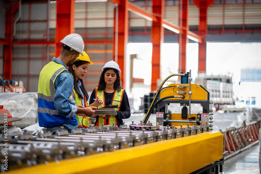 Team of young male and female engineers in a metal sheet factory Responsible work is being inspected at the actual work site. Team of young male and female engineers in a metal sheet factory Responsible work is being inspected at the actual work site.