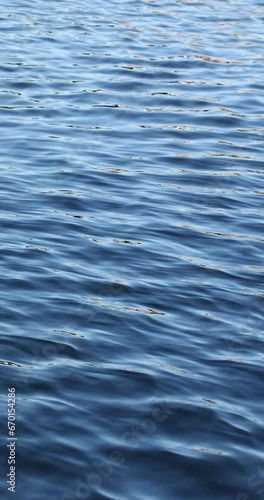 Ripple and small waves on the blue water surface, water texture, abstract natural background