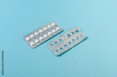 empty and full blister packs of pills on blue background. healthcare and medicine concept.
