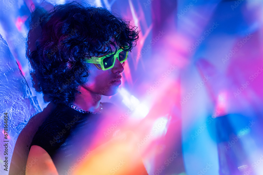 Contemplative latin man with neon shades among lights Contemplative latin man with neon shades among lights