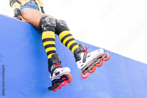 Woman Wearing Yellow Striped Socks And Roller Skate Shoes At skate park photo