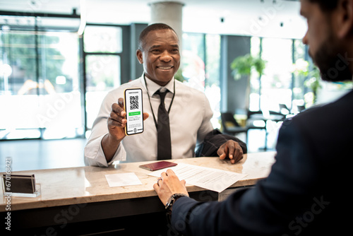 Businessman showing a vaccine certificate at the hotel reception