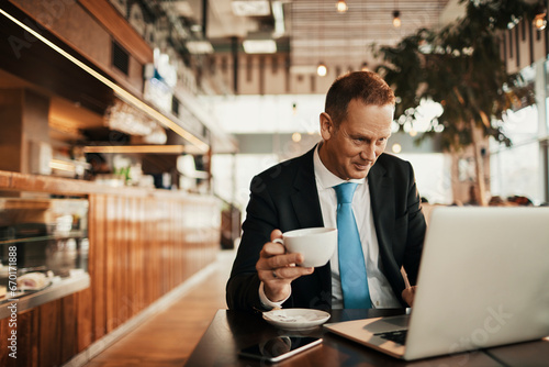 Φωτογραφία Mature businessman holding a cup of coffee in a cafe