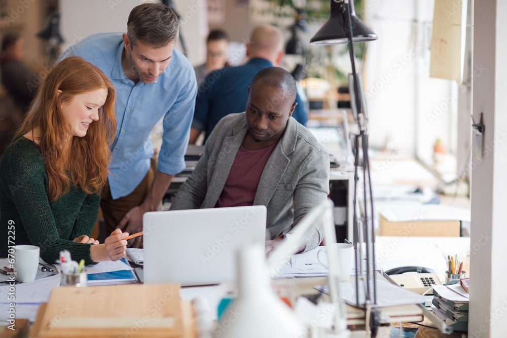 Diverse trio of designers working in a modern office