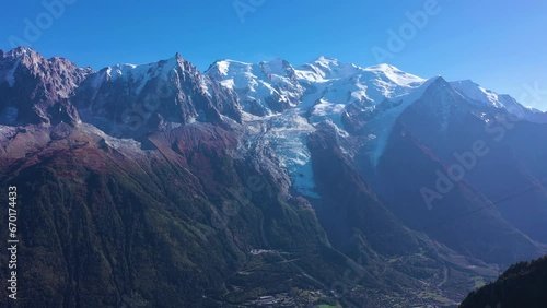 Mont Blanc and Aiguille du Midi Mountains on Sunny Day. French Alps, France. Aerial View. Drone Flies Backwards over a Rocky Mountain at Low Level