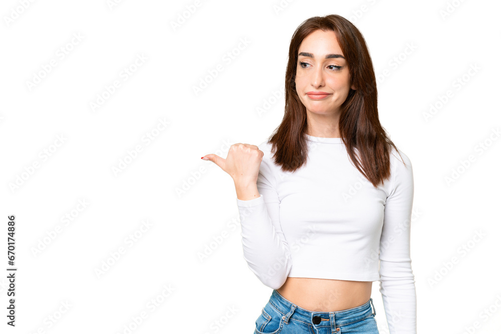 Young caucasian woman over isolated chroma key background unhappy and pointing to the side Young caucasian woman over isolated chroma key background unhappy and pointing to the side