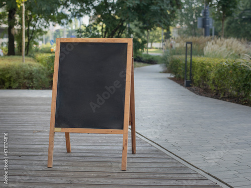 Empty sandwich chalkboard stand on street to fill