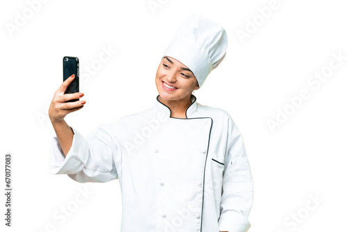 Young woman Chef over isolated chroma key background making a selfie